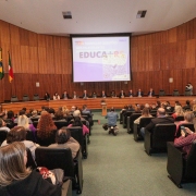 foto geral do evento, no fundo do auditório, mostrando a mesa de abertura e o público