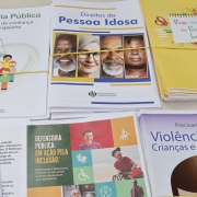 Foto de cartilhas informativas que abordam temas como vagas em creches, direitos da pessoa idosa, e que estavam disponíveis para os assistidos.