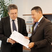 foto do senador entregando o ofício com a doação para o defensor geral. ambos estão olhando para o documento