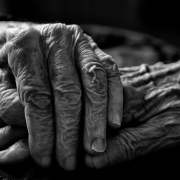 foto de duas mãos idosas, uma por cima da outra, em preto e branco