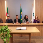 foto geral da mesa da cerimônia, composta por três mulheres e três homens