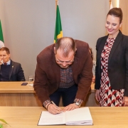 Foto de um dos servidores assinando o termo de posse, com a subdefensora administrativa ao lado, acompanhando