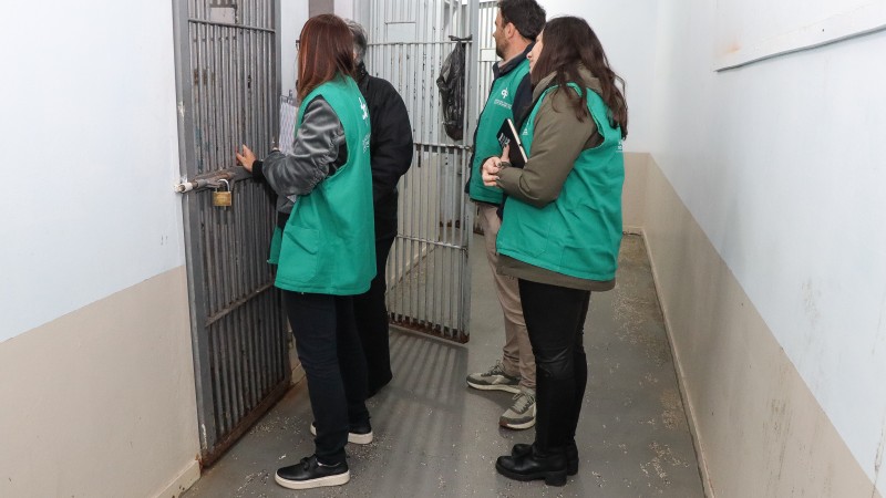 Foto de três defensores conversando com os jovens através das grades