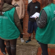 Foto geral de duas defensoras de costas conversando com dois jovens não identificados que estão de frente para elas