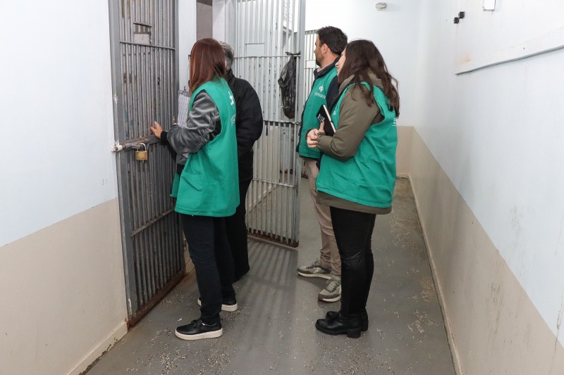 Foto de três defensores conversando com os jovens através das grades