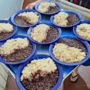 Servidor do  Presídio Estadual de Lavras do Sul serve nove pratos de arroz e feijão em uma bandeja azul