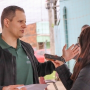 defensor público dando entrevista para uma jornalista, que está gravando um áudio com um celular