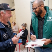 Foto geral de um defensor público conversando com um assistido