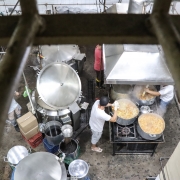 Imagem da cozinha da penitenciária. Vê-se homens cozinhando em grande panelas