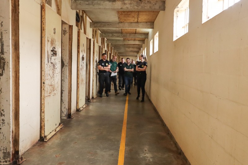 Foto de um dos corredores internos das galerias. Defensores e agentes da SUSEPE caminham por ele