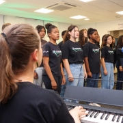 Maestrina, no teclado, e coral do projeto Ouviravida.