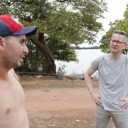 Dois homens em pé à beira do Rio Guaíba