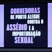 Uma tela com uma arte digital escrito "Corredoras de Porto Alegre contra o Assédio e Importunação Sexual".