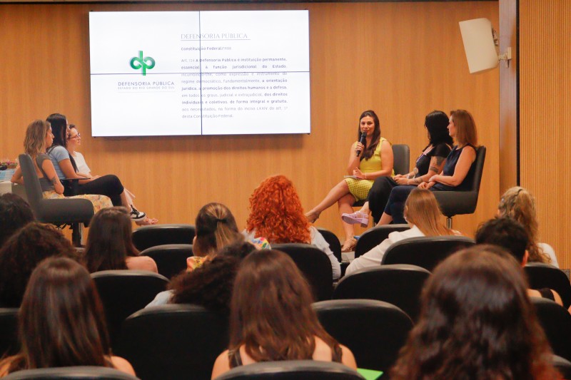 Foto geral da defensora pública palestrando para as mulheres na Escola GHC