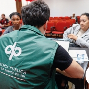 Foto geral de um defensor de costas prestando atendimento a um assistido