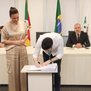 Foto geral da subdefensora pública ao lado do novo empossado