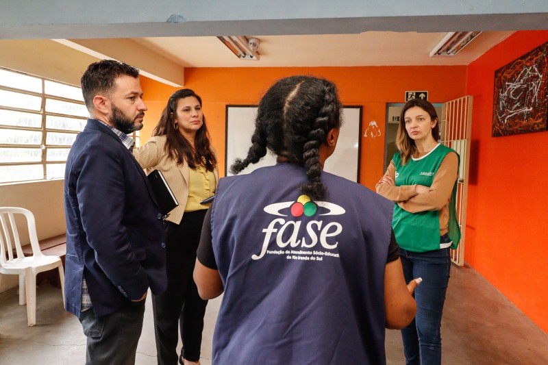 Defensores públicos conversam com servidora da FASE durante inspeção.