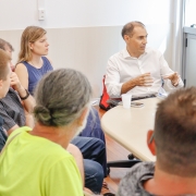 Pessoas em uma sala sentadas a uma mesa redonda