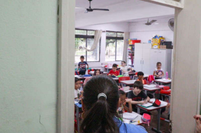 Paula observa sala de aula com alunos.