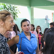 Mulheres conversam no pátio da escola.