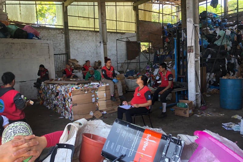 foto de um centro de reciclagem, com os materiais sendo separados pelos catadores