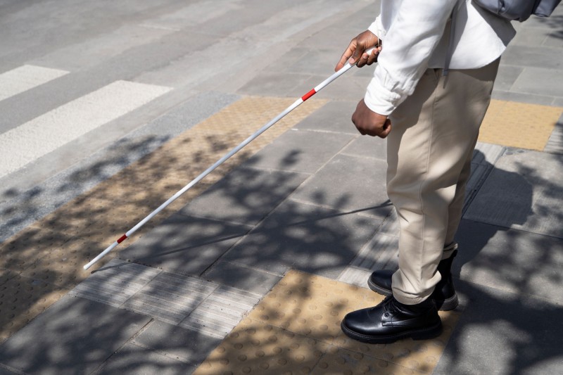 Homem com deficiência visual atravessando a rua